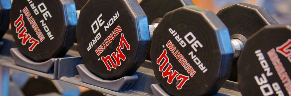Free weights with Loyola Marymount University's logo sit at the Burns Recreation Center on campus.